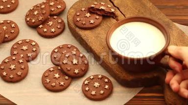 在旧木砧板上的粘土杯中放入热牛奶，在羊皮纸上放入新鲜的烤巧克力饼干